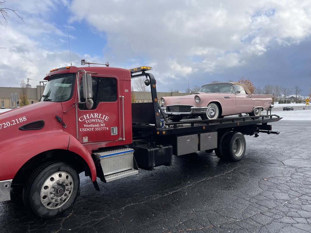 Charlie Towing flatbed hauling a pink classic Thunderbird convertible in Westland, Michigan